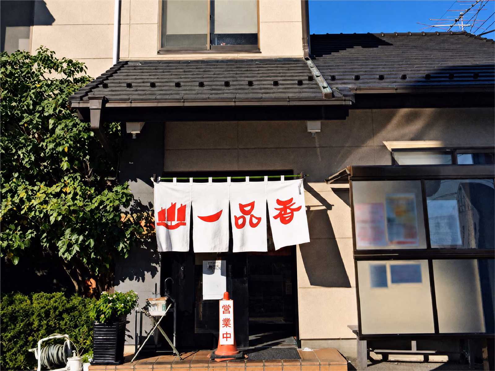 一品香 小山の外観。白い暖簾に赤い『一品香』の文字、入口に営業中の看板